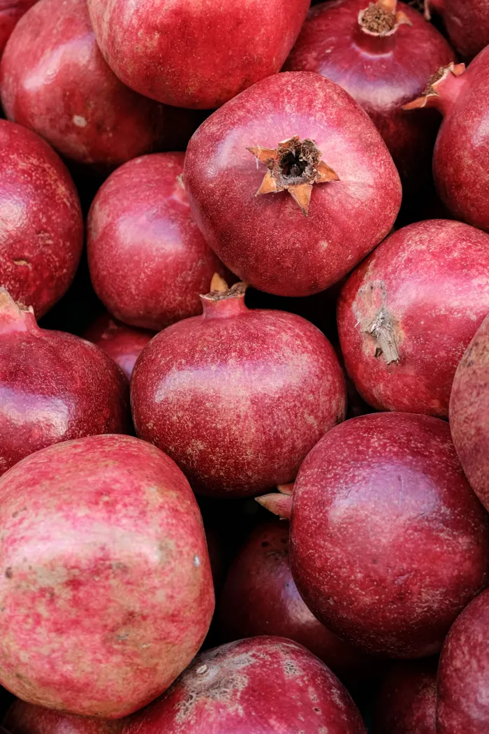 Fresh ripe pomegranates arranged in a stack