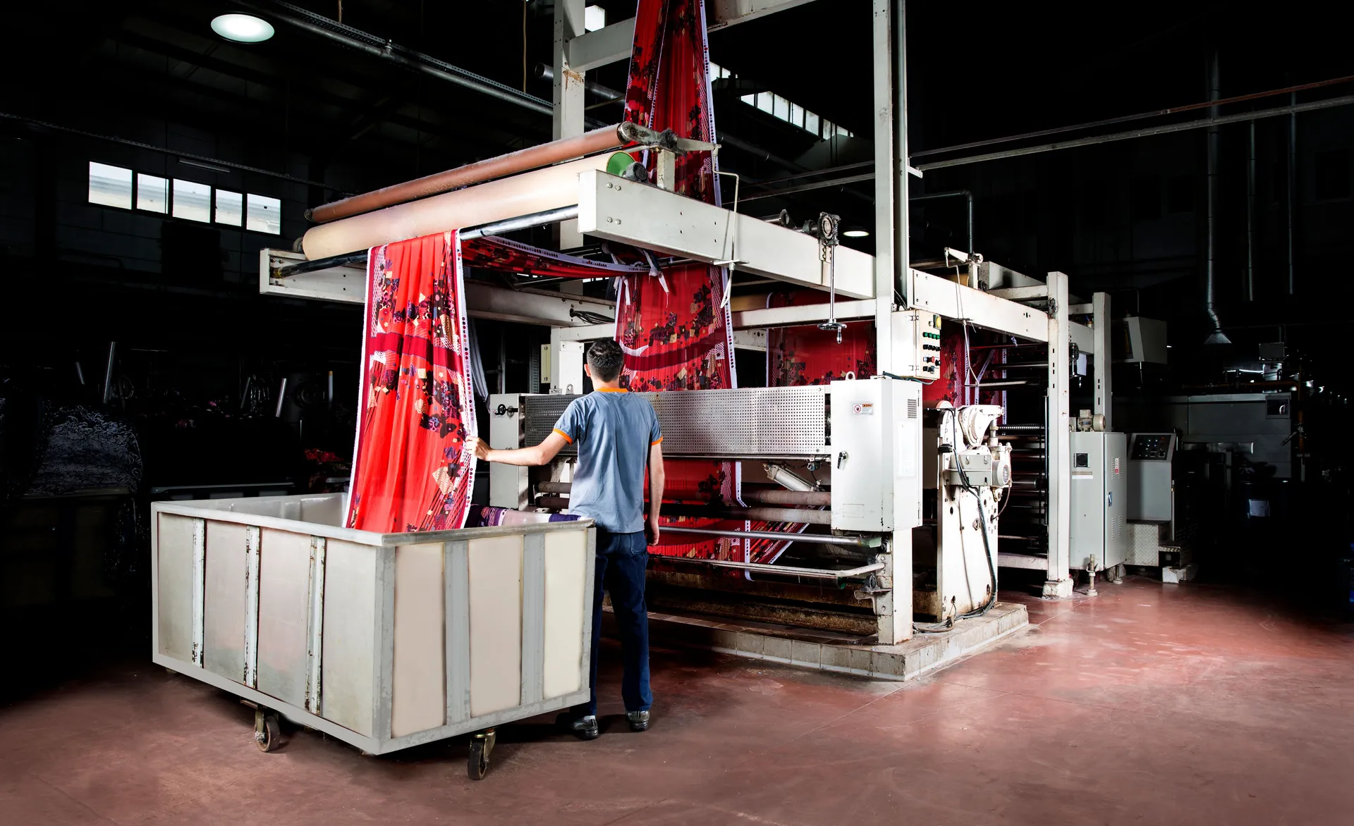 Worker overseeing fabric production in a textile factory